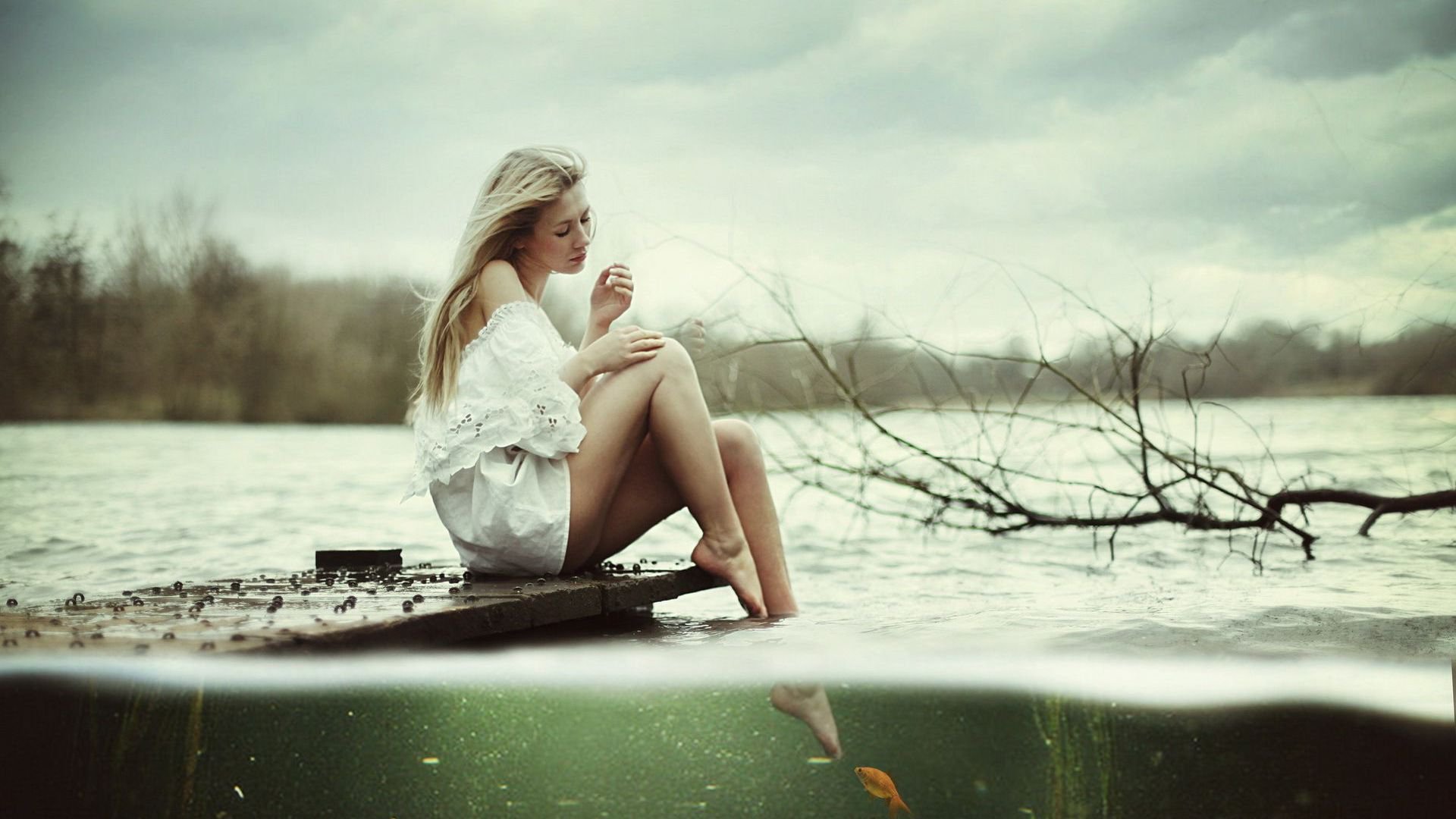 Худенькая блондинка на берегу озера показывает прелести