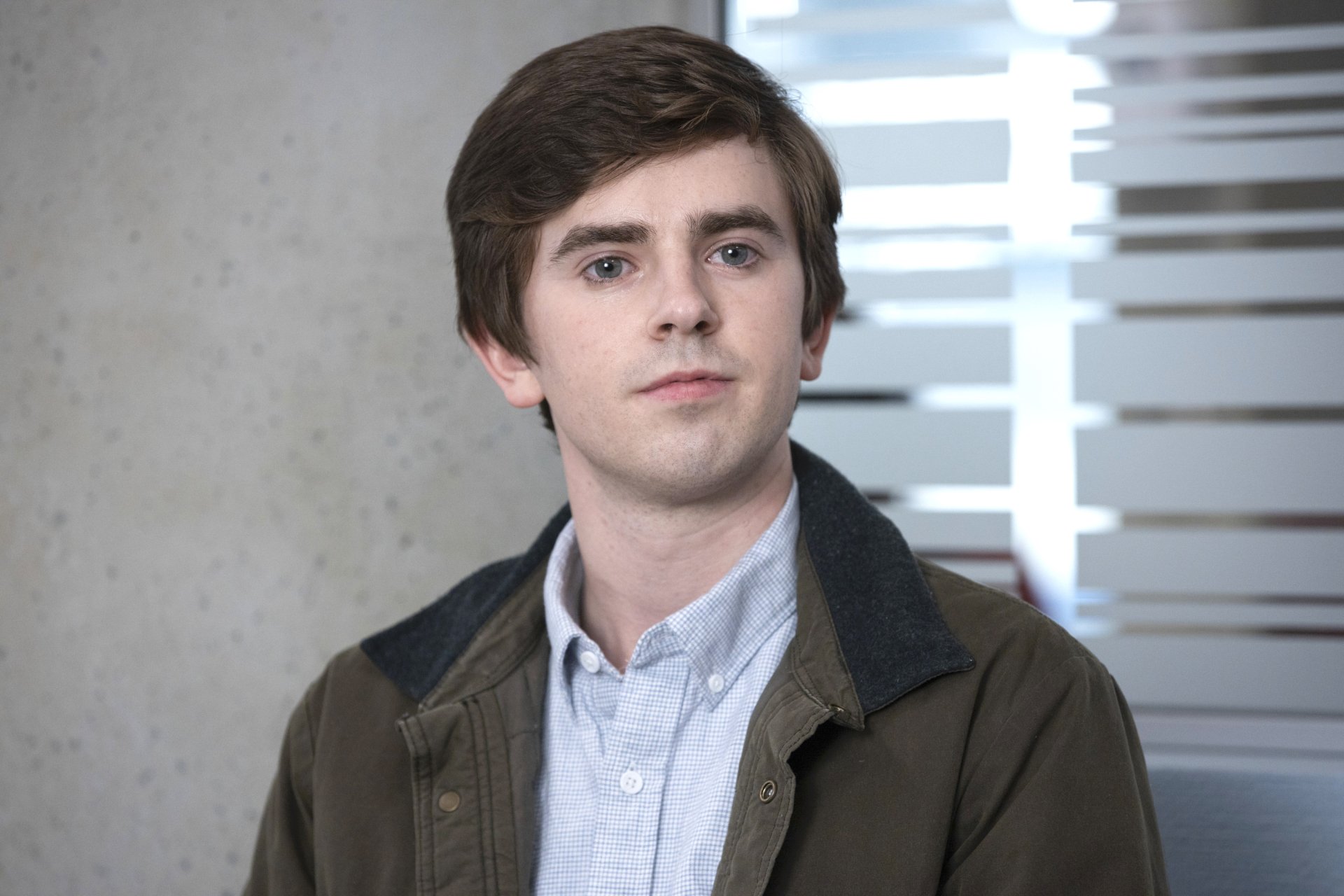 HD desktop wallpaper featuring a thoughtful portrait of Freddie Highmore from The Good Doctor series.