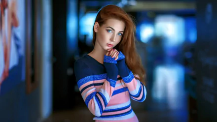 HD desktop wallpaper of a redheaded model with long hair and blue eyes, hands near her face, soft depth-of-field background.