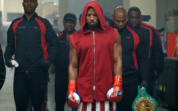 HD wallpaper featuring Michael B. Jordan as Adonis Creed in Creed II, ready to box with team in background.