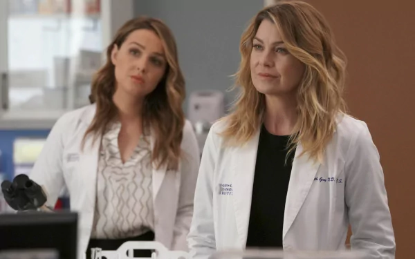 HD desktop wallpaper of two female characters from Grey's Anatomy in white lab coats, set in a medical environment.