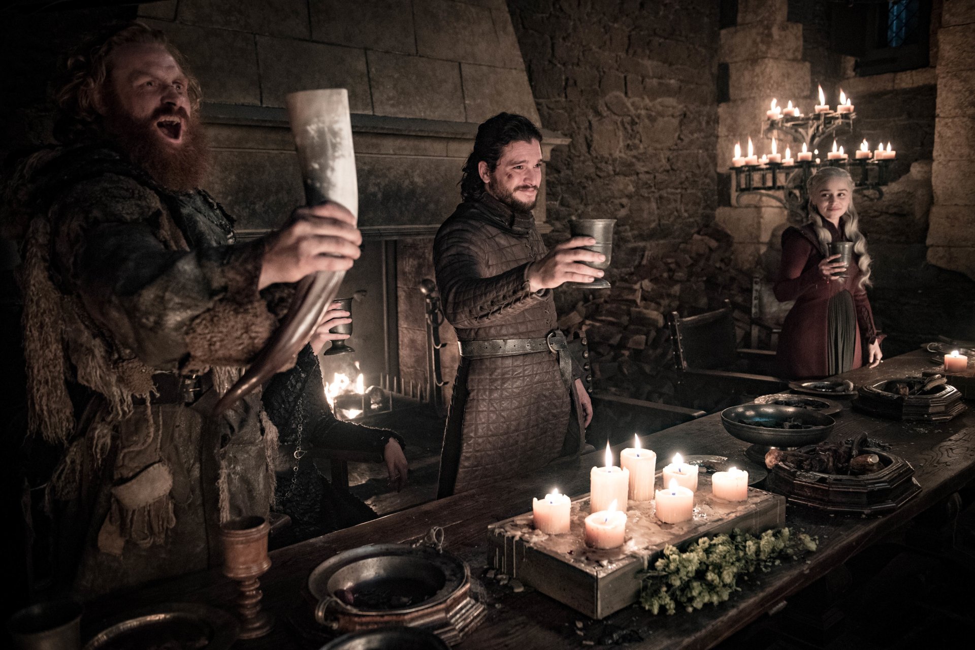 Game of Thrones TV wallpaper: Tormund Giantsbane, Jon Snow and Daenerys Targaryen cheer with cups at a candlelit feast.