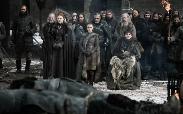 2K Quad HD wallpaper: Game of Thrones scene with Bran Stark seated, Arya and Sansa Stark and allies including Davos Seaworth and Sandor Clegane standing in a snowy courtyard, tense crowd behind.