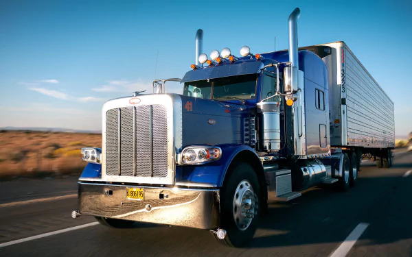 HD desktop wallpaper featuring a blue Peterbilt truck driving on a highway under a clear sky.