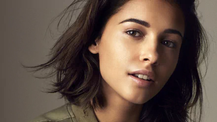 Close-up portrait of actress Naomi Scott with short black hair and brown eyes, featured as an HD PC desktop wallpaper background.