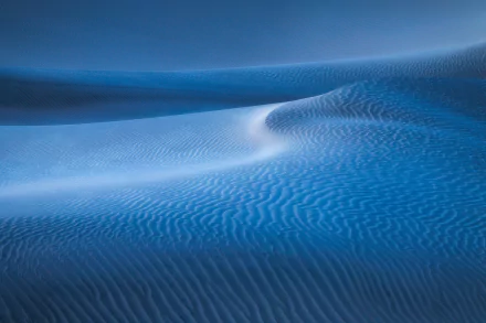 HD PC desktop wallpaper showcasing smooth, rippled sand dunes under soft blue lighting in a serene desert landscape.