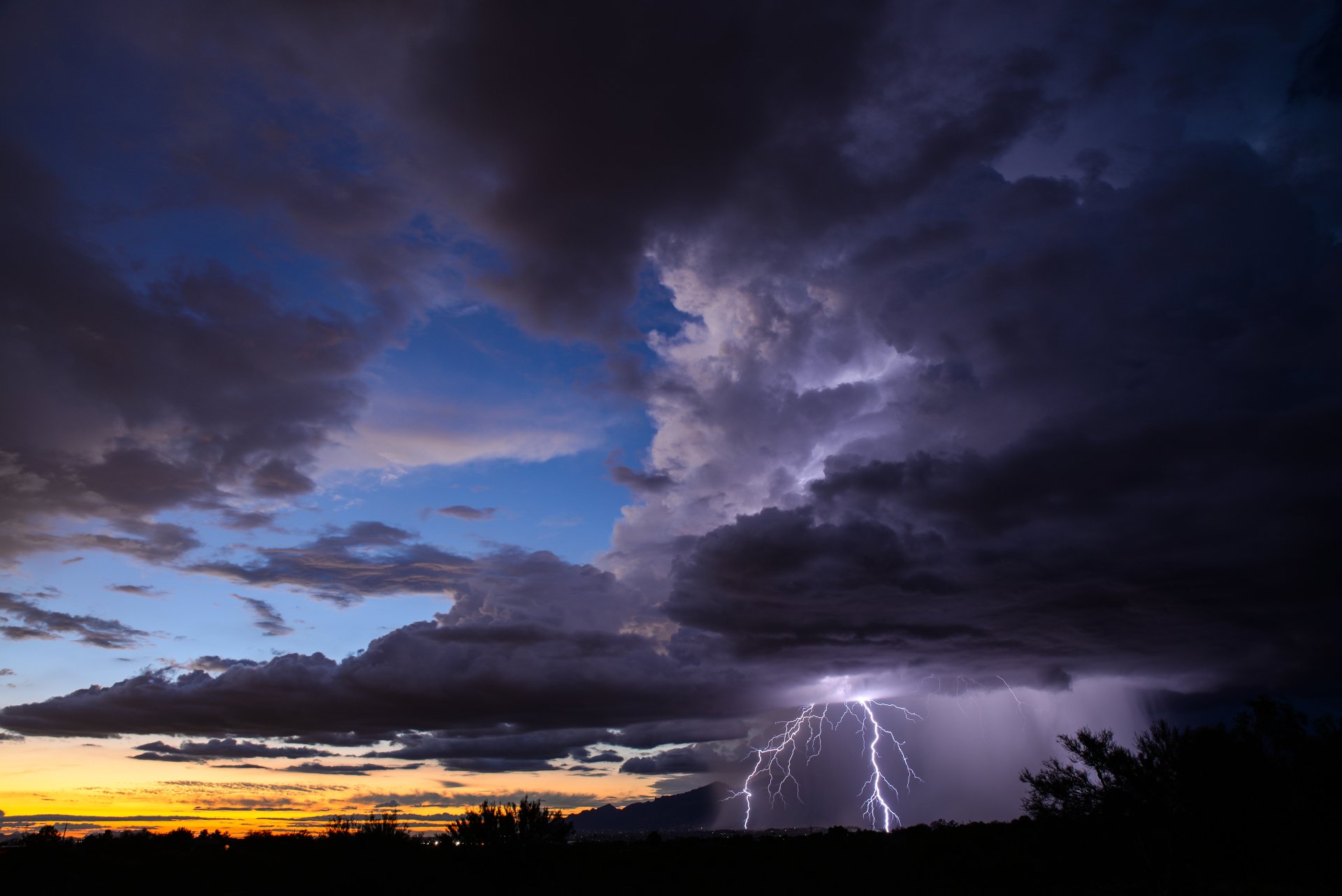 4K Ultra HD photography capturing dramatic lightning bolts striking beneath dark storm clouds at dusk, creating a powerful and dynamic desktop wallpaper background.