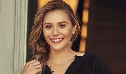 HD PC desktop wallpaper featuring a smiling Elizabeth Olsen with loose hair, wearing a black top against a softly lit background.