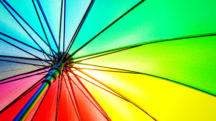 Photograph of a rainbow umbrella canopy in vivid colors, radiating spokes — 4K Ultra HD PC desktop wallpaper and background.