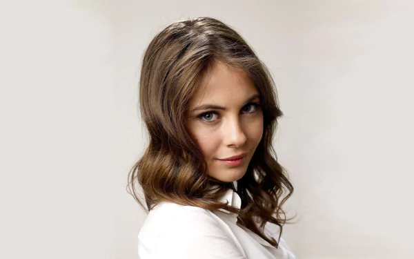 HD desktop wallpaper featuring American brunette actress and celebrity Willa Holland with soft waves and a confident expression against a neutral background.
