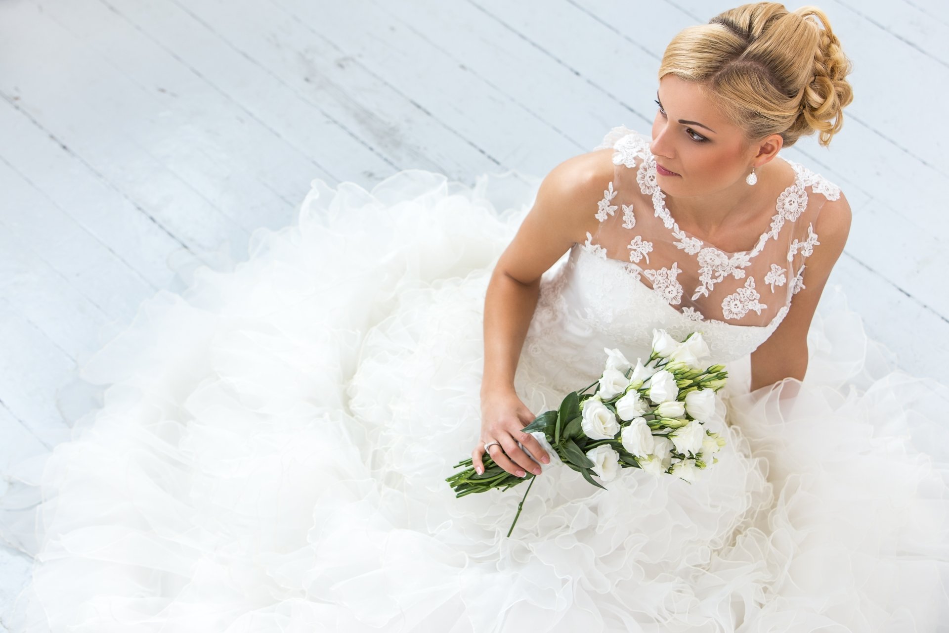 Blonde bride model in a lace white wedding dress holding a white flower bouquet, 4K Ultra HD PC desktop wallpaper and background.