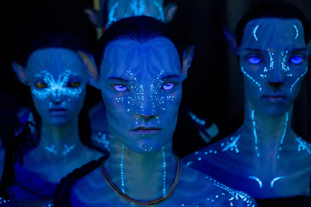 HD desktop wallpaper featuring glowing Na'vi characters from the movie Avatar: The Way of Water in a dark, blue-lit setting.