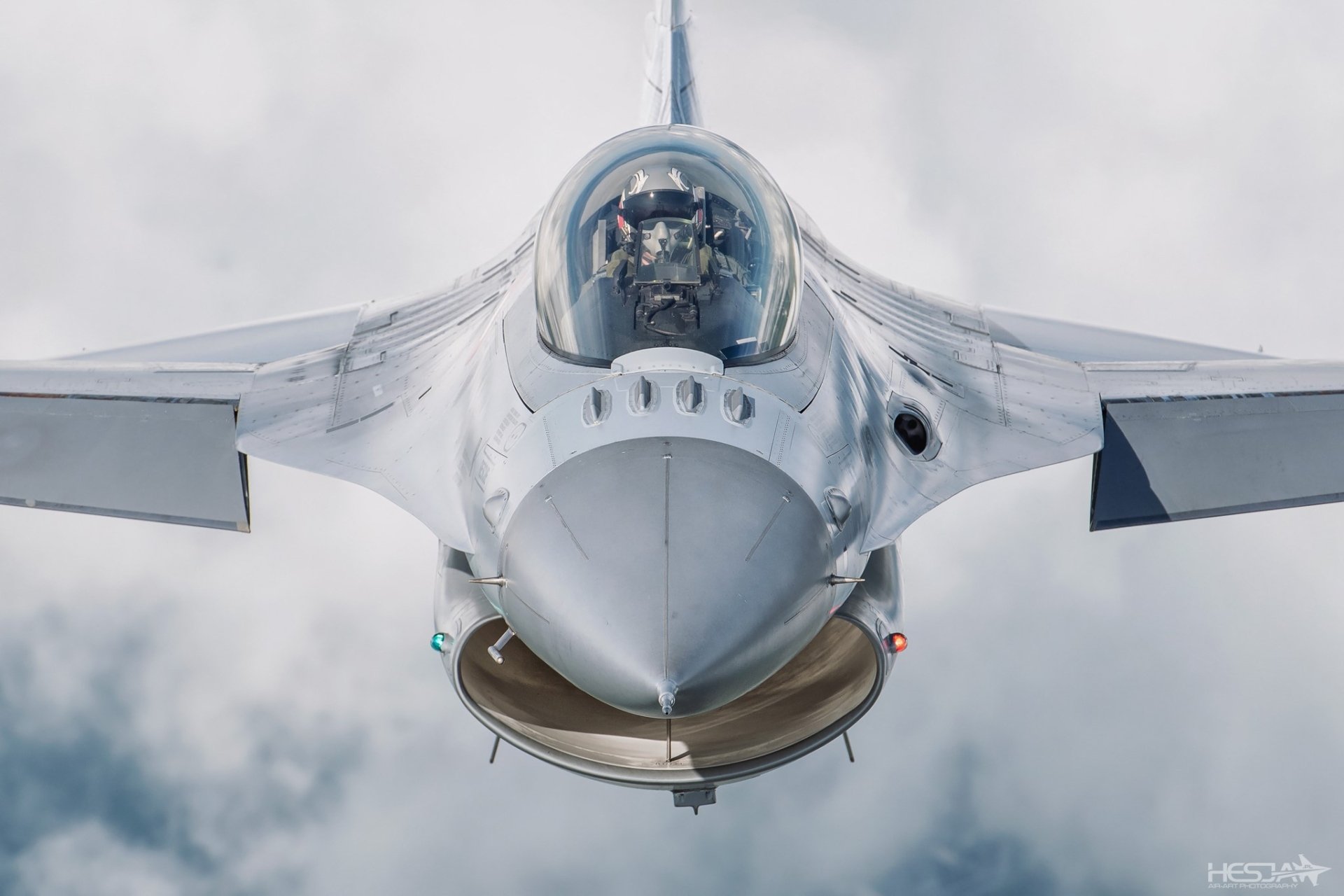 Front view of a General Dynamics F-16 Fighting Falcon jet fighter piloted in flight, captured in high-definition military aircraft wallpaper style.