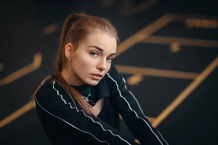 HD desktop wallpaper featuring a redhead woman model with striking blue eyes against a blurred dark background with geometric light patterns.