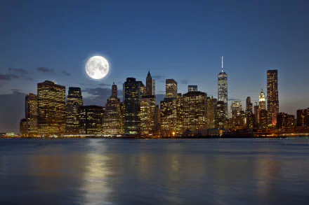 4K Ultra HD night view of Manhattan, New York with a radiant full moon illuminating the city skyline reflected on the water.