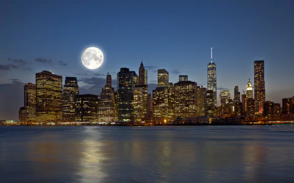 4K Ultra HD night view of Manhattan, New York with a radiant full moon illuminating the city skyline reflected on the water.