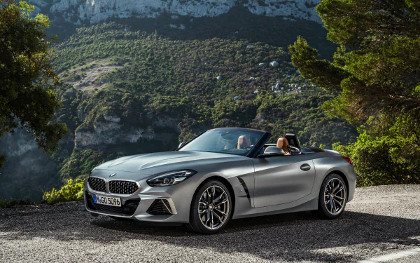 Silver BMW Z4 cabriolet with roof down on a mountain road, sporty BMW vehicle captured as a 4K Ultra HD PC desktop wallpaper and background.
