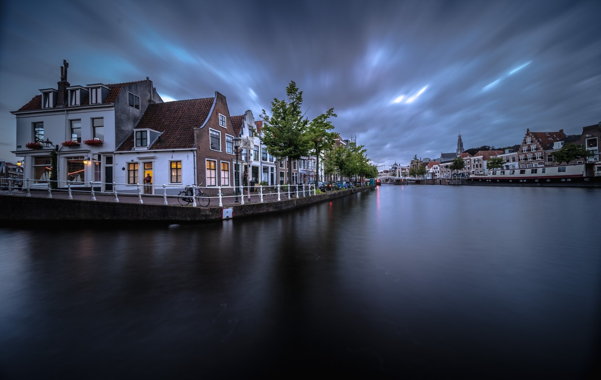 Twilight view of Haarlem, Netherlands: riverside houses and man-made cityscape reflected on a calm river — HD PC desktop wallpaper background.
