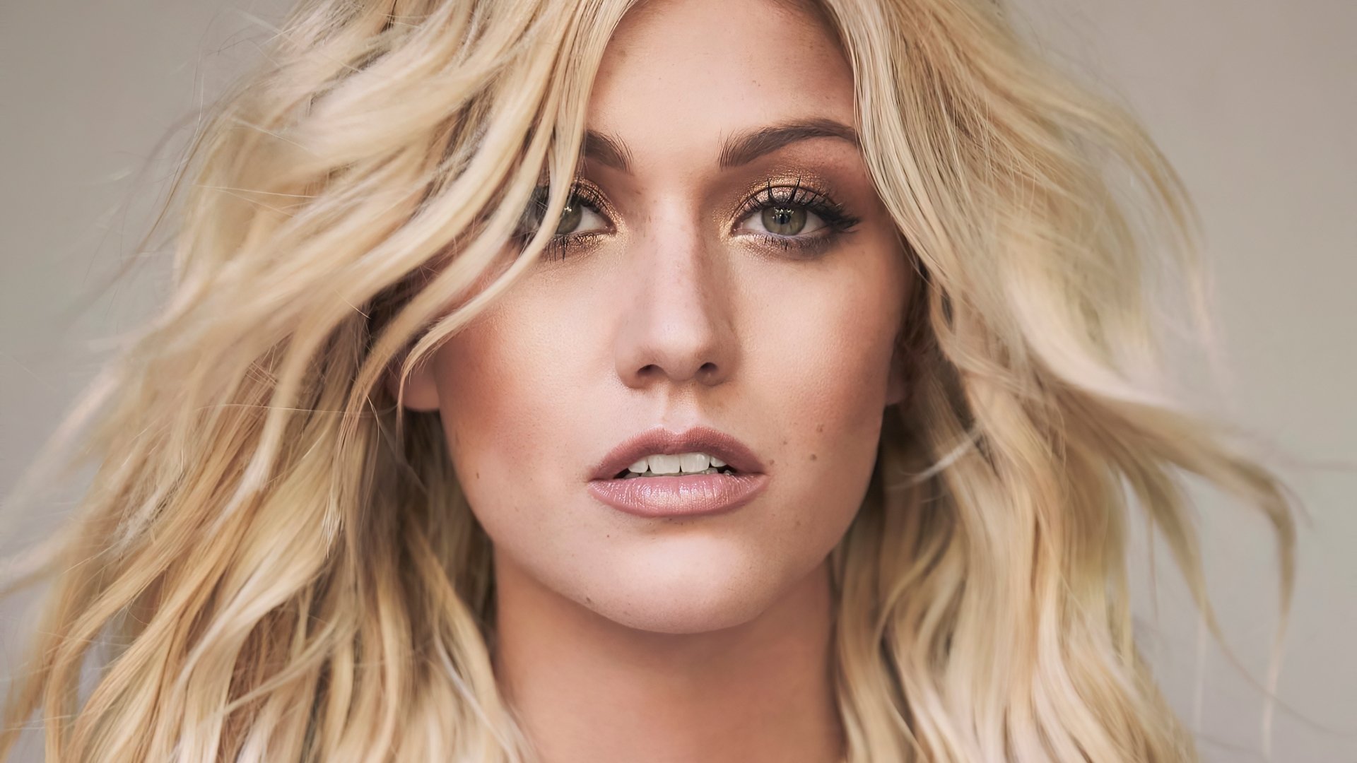 Close-up HD portrait of blonde actress Katherine McNamara with natural makeup, featuring her face as a striking PC desktop wallpaper background.