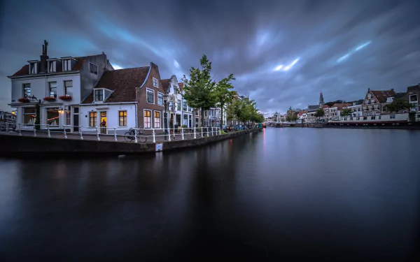 Twilight view of Haarlem, Netherlands: riverside houses and man-made cityscape reflected on a calm river — HD PC desktop wallpaper background.