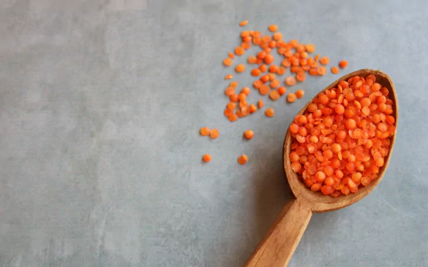  Red lentils in a wooden spoon by Mati Michael