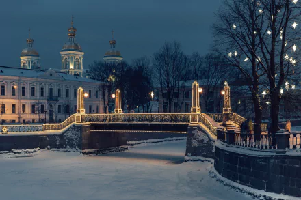 Night view of a snowy winter scene in Saint Petersburg, Russia, featuring a softly lit bridge over a frozen river with historic buildings in the background.