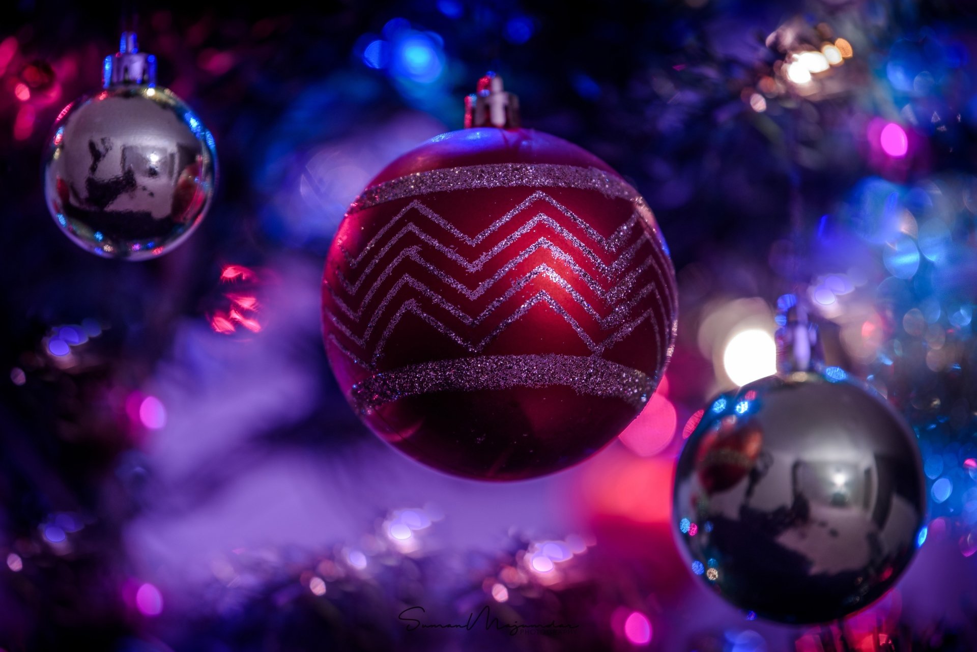 Close-up of red and silver Christmas tree ornaments with colorful bokeh lights — festive holiday decoration, 4K Ultra HD PC desktop wallpaper and background.