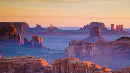 Breathtaking HD desert landscape of Monument Valley, Arizona, USA, showcasing iconic sandstone formations under a softly colored sky.