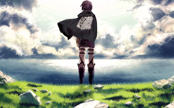 HD wallpaper featuring Eren Yeager from Attack on Titan, standing on a grassy field overlooking water, wearing the Scouting Legion cloak, with dramatic clouds in the background.