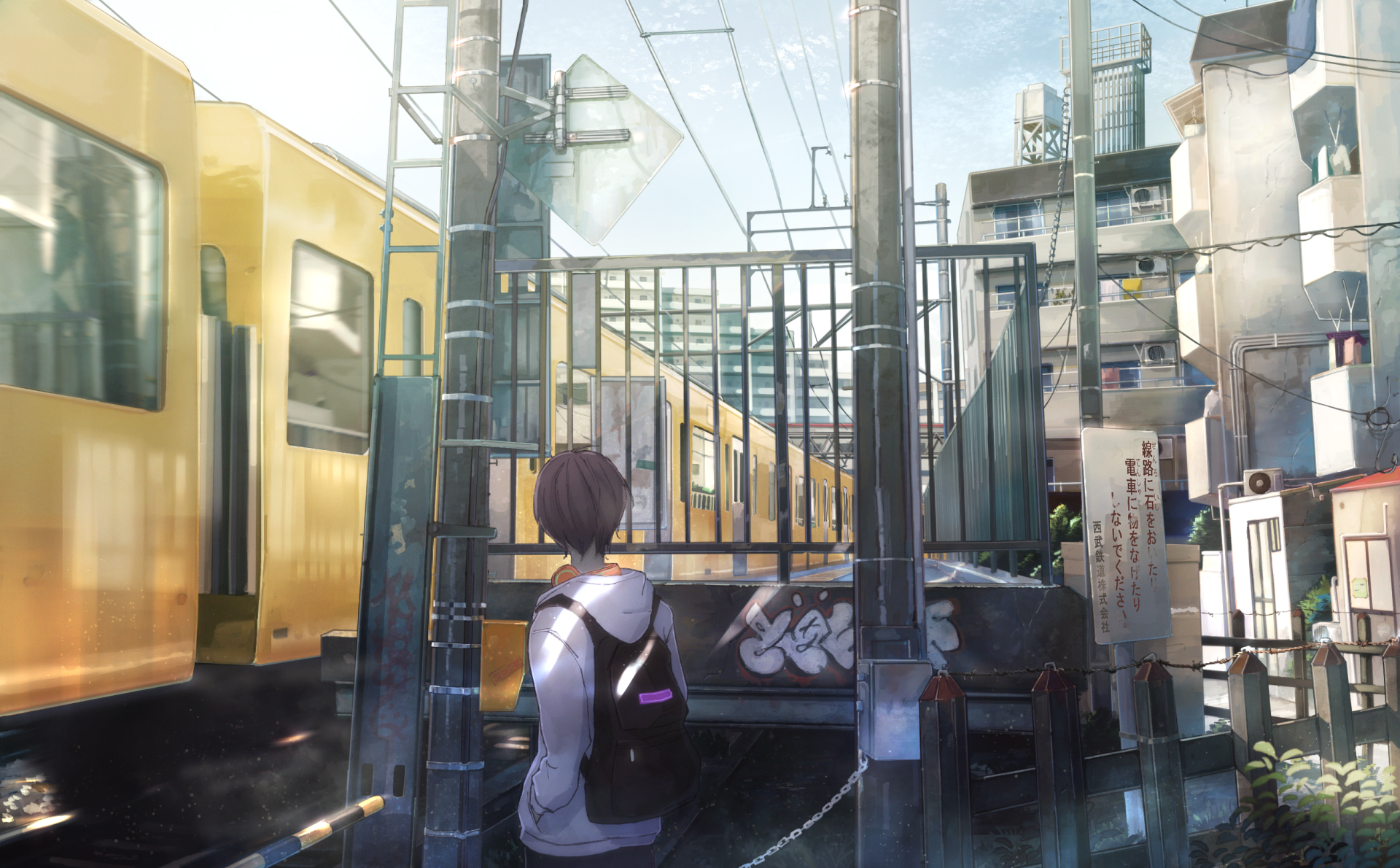 HD anime desktop wallpaper featuring an anime boy standing near a train platform in a detailed urban setting with yellow trains and buildings in the background.