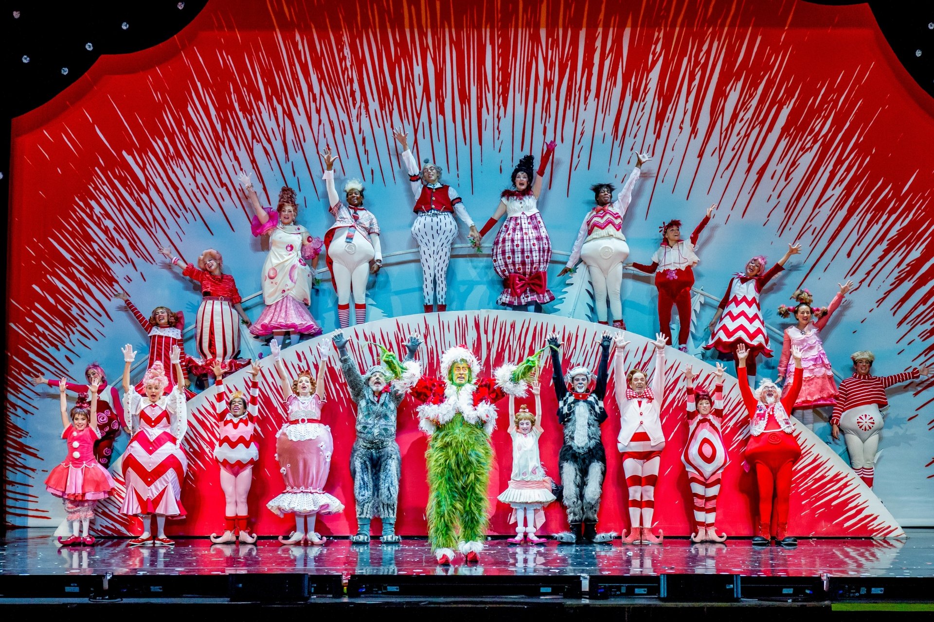 HD wallpaper of 'Dr. Seuss' The Grinch Musical' with performers on stage in colorful costumes and a festive set design.