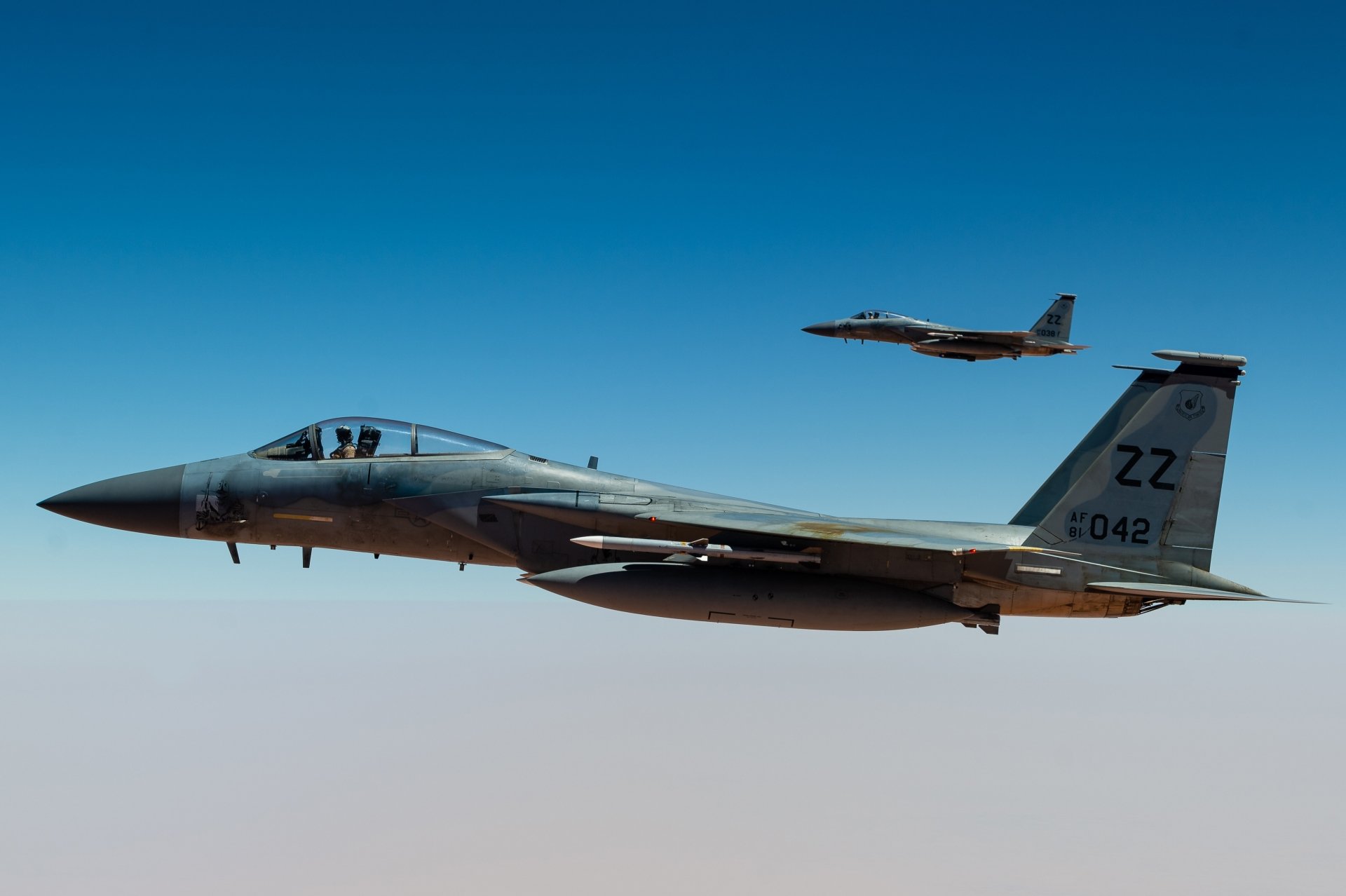 Two McDonnell Douglas F-15 Eagle jet fighter warplanes fly against a clear blue sky in this 4K Ultra HD military aircraft desktop wallpaper.