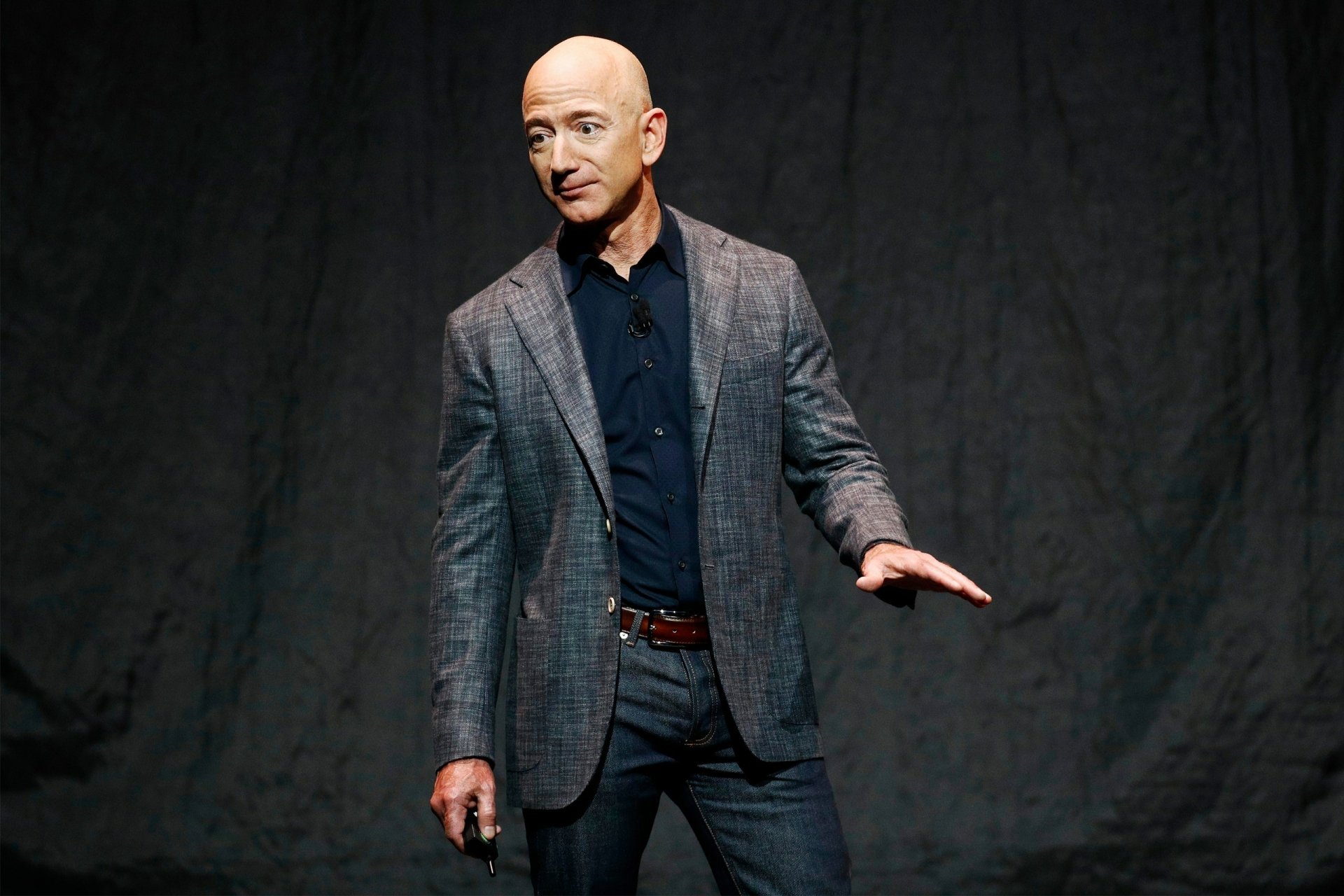 HD wallpaper of a man in a blazer presenting on stage, offering a professional and motivational backdrop.