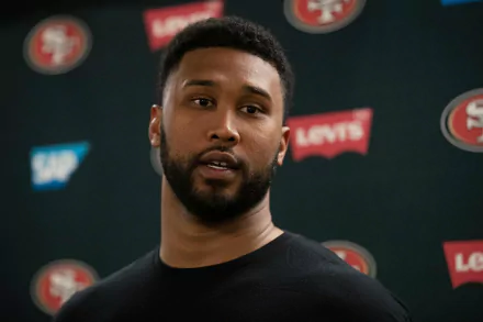 High-definition desktop wallpaper featuring DeForest Buckner, showcasing the athlete during a press conference in front of a San Francisco 49ers backdrop.