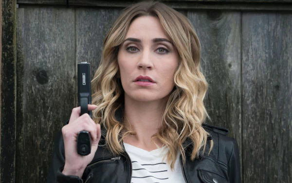 HD wallpaper featuring Jessica Harmon holding a radio, with a serious expression in front of a wooden background.