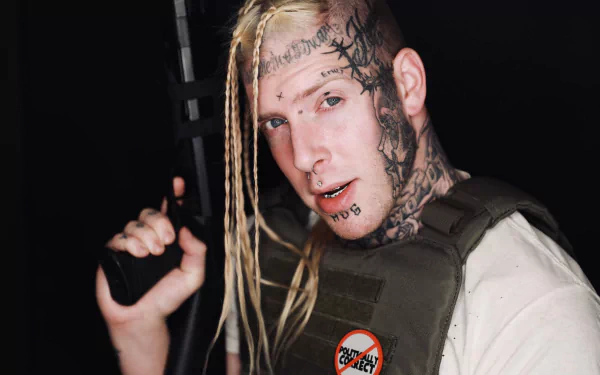 HD wallpaper of Tom MacDonald with tattoos, pierced face, and a serious expression, suitable as a desktop background.