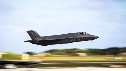 Motion blur captures a Lockheed Martin F-35 Lightning II jet fighter in flight over a blurred landscape. Military warplane shown in 4K Ultra HD detail.