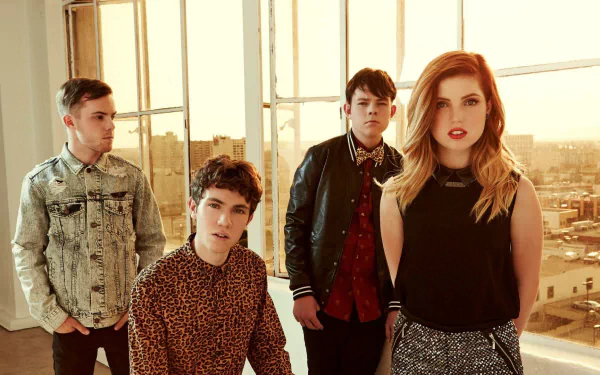 Echosmith band members, including Sydney Sierota, posing in a room with a city view, in an HD desktop wallpaper format.