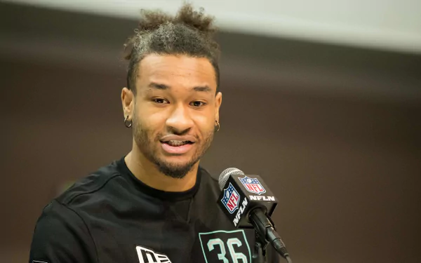 A high-definition desktop wallpaper featuring Jeremy Chinn, a professional football player, speaking at a press event. His dynamic expression captures the excitement of the sports world.