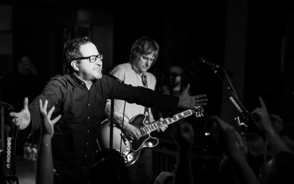 HD desktop wallpaper of The Hold Steady in concert, featuring a vocalist engaging the audience and a guitarist in the background.