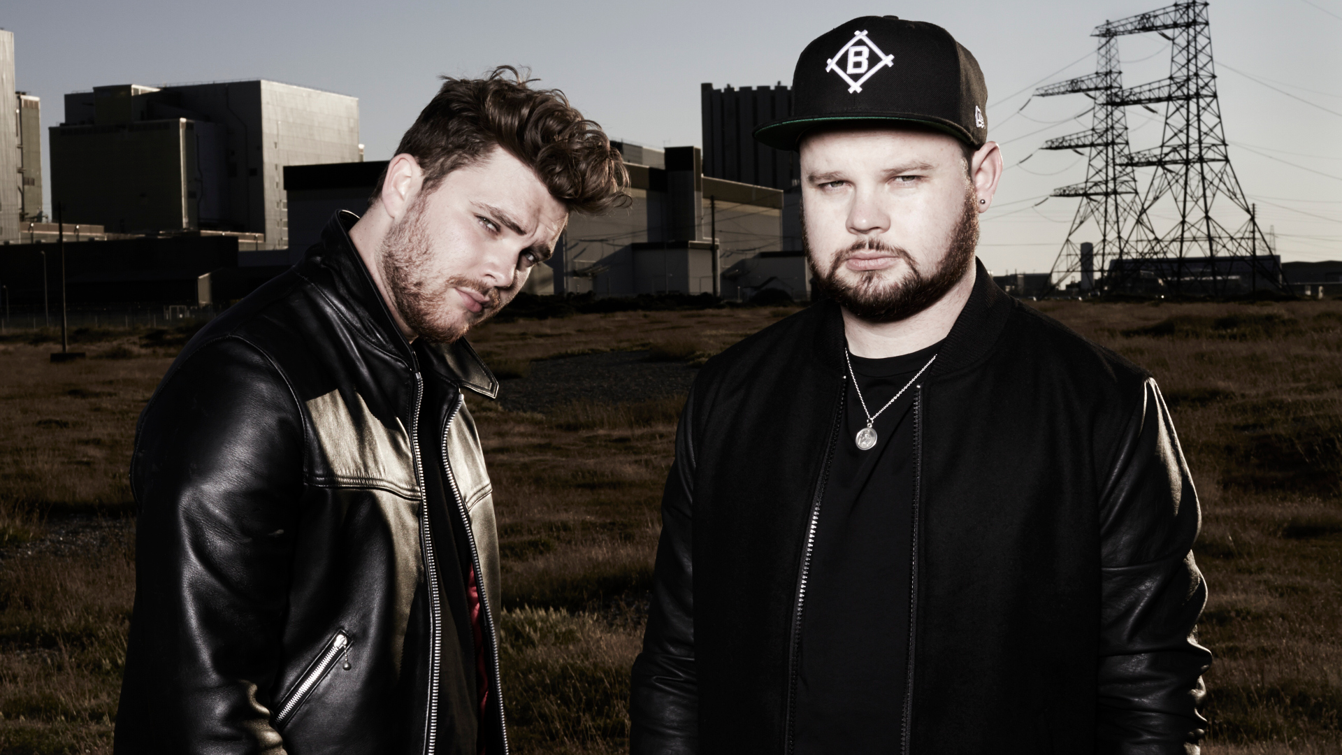 Royal Blood band members posing for an HD desktop wallpaper with an industrial backdrop.