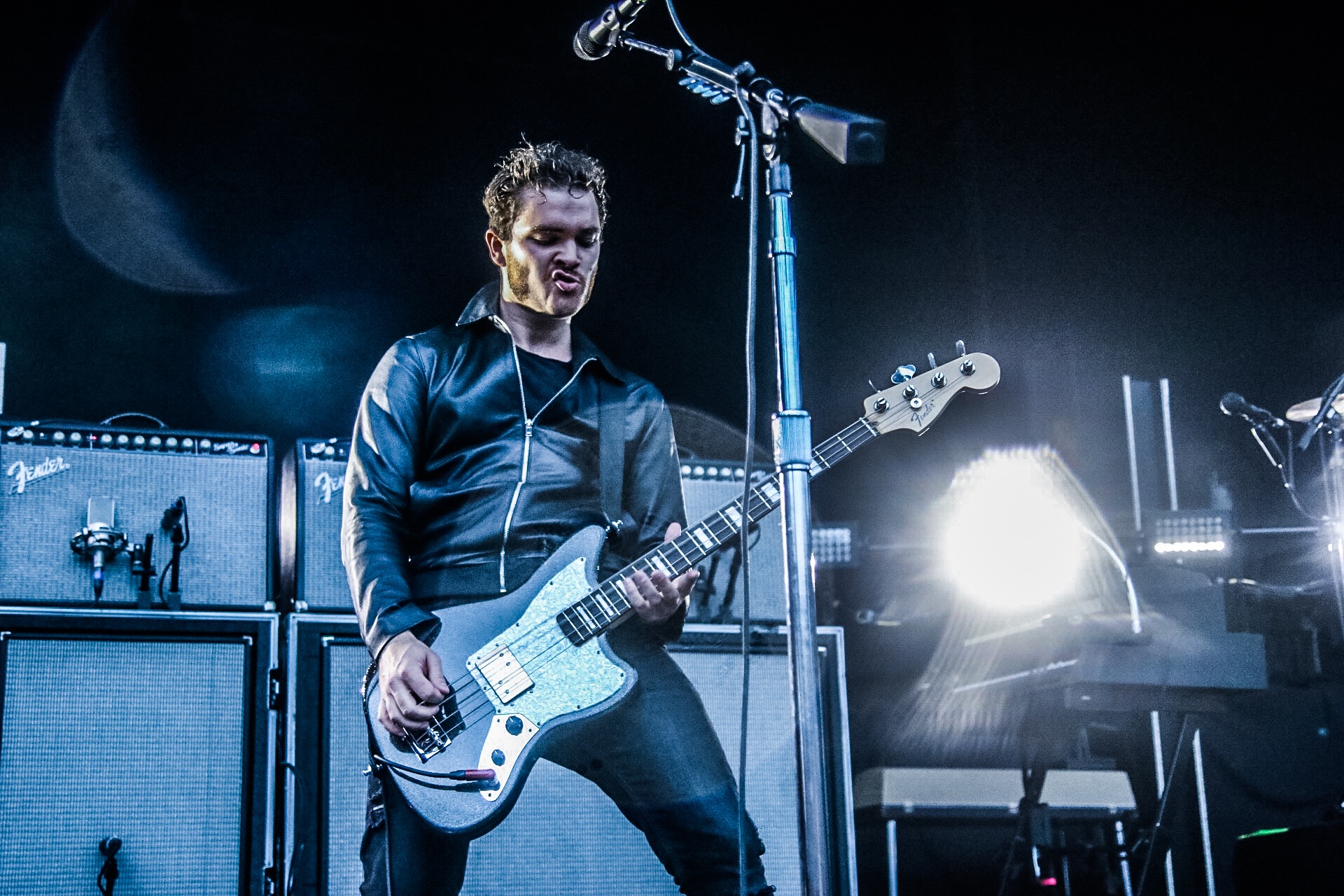 Rock musician performing live with electric guitar, bathed in stage lights, Royal Blood theme HD desktop wallpaper.