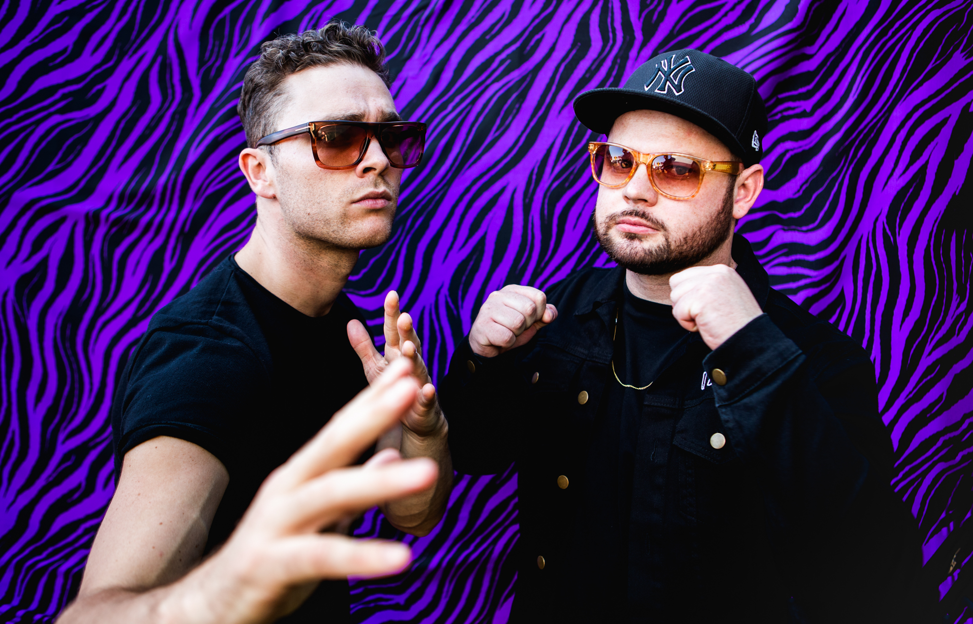 HD desktop wallpaper featuring two stylish band members in front of a vibrant purple patterned background, tagged Royal Blood.