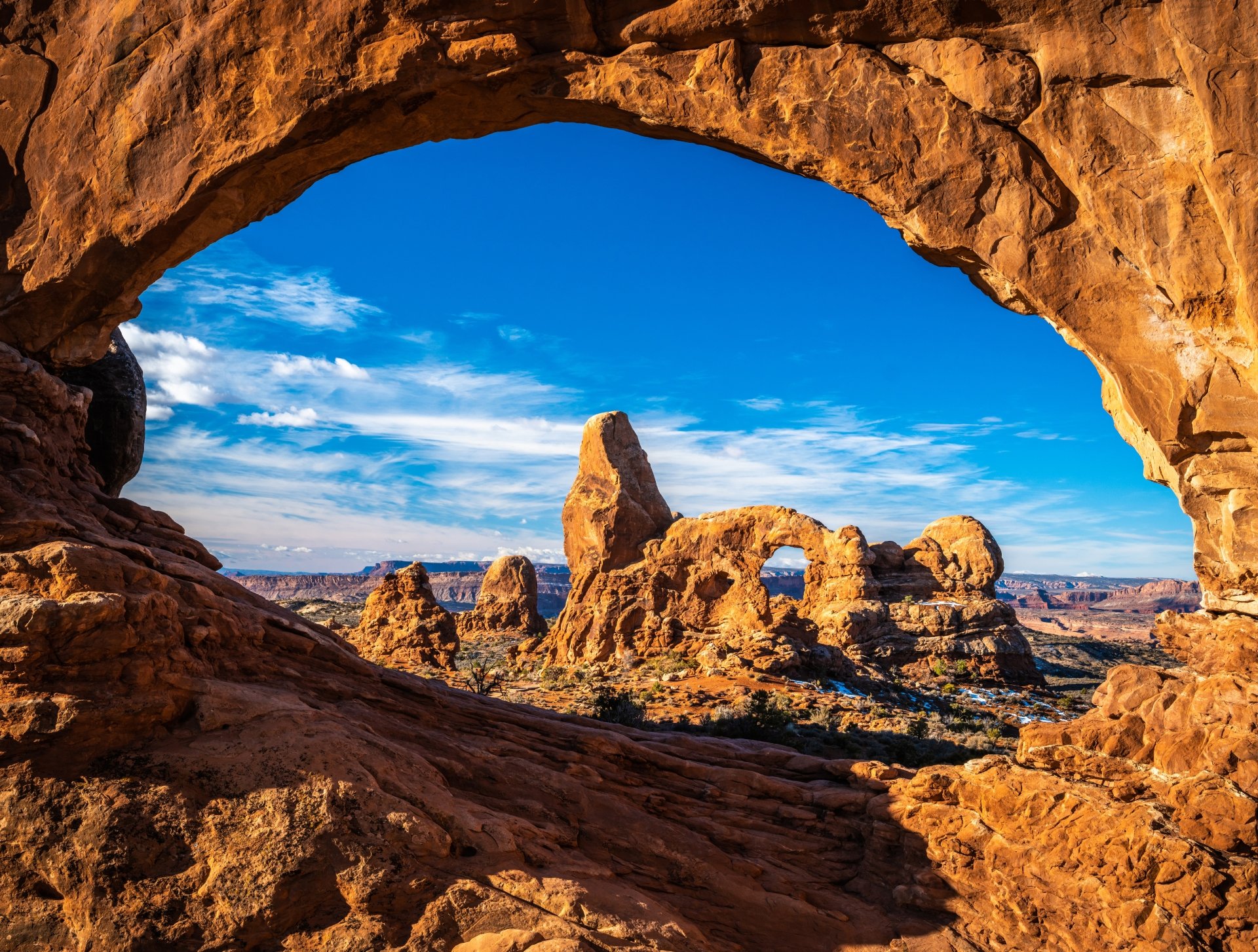 A stunning 4K Ultra HD wallpaper of Utah’s desert landscape showcasing natural rock arches under a bright blue sky in the USA.