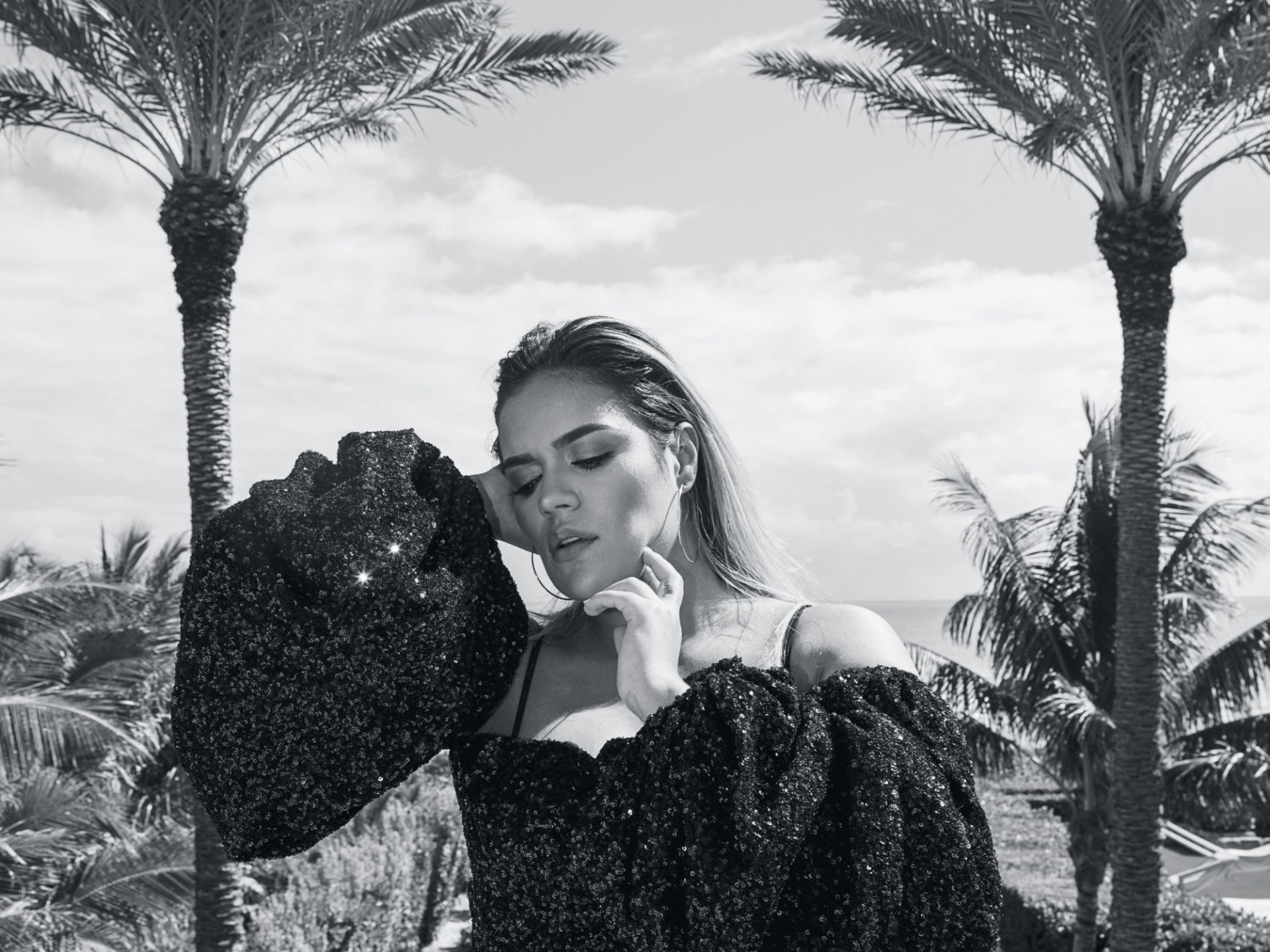 HD desktop wallpaper featuring a monochrome image of a woman in elegant attire posing with palms in the background.