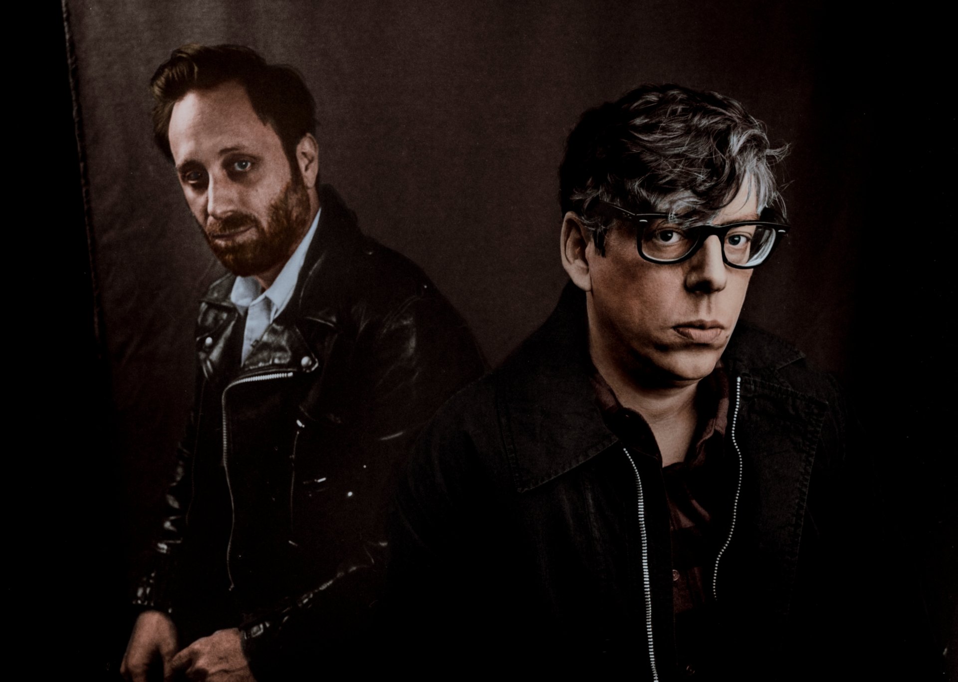 HD wallpaper featuring two band members, posing for a dark, moody portrait suitable as a desktop background.
