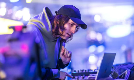 HD desktop wallpaper of a person DJing at an event, with vibrant blue lighting in the background.