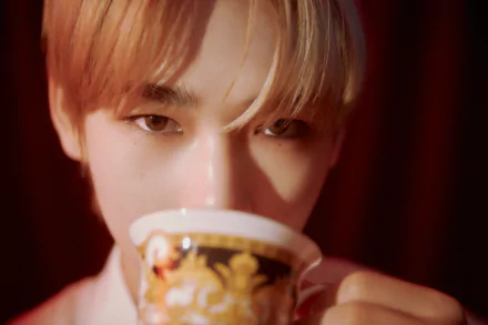 Close-up of an ENHYPEN member sipping from a decorative cup, captured in 4K Ultra HD, designed as a PC desktop wallpaper with a warm, intimate atmosphere.