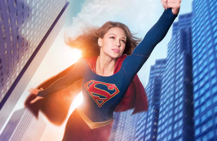 HD desktop wallpaper featuring Melissa Benoist as Kara Danvers from the TV show Supergirl, soaring through a city skyline.