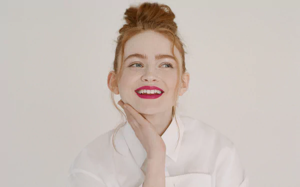 4K Ultra HD image of American actress Sadie Sink with red lipstick, smiling against a plain background, styled for a PC desktop wallpaper.